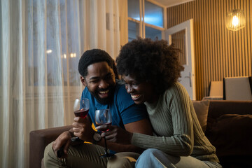 African american couple having romantic date at home while drinking wine 