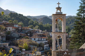 White bell tower overlooking Platanistasa village in Troodos mountains, Cyprus