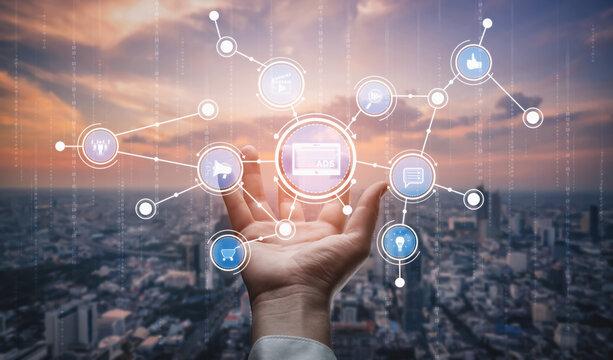 A hand reaches out toward floating digital icons symbolizing social media and marketing, set against a stunning city skyline during sunset, showcasing technology interaction. Tessel