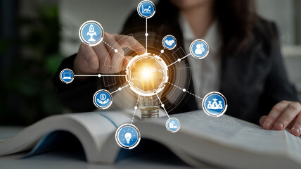 A businesswoman interacts with digital icons on an open book, symbolizing the integration of learning and transformation in a modern workspace environment. Crux