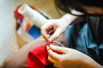 Close-up of Hands Knitting Bright Red Yarn
