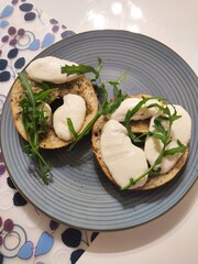 Bagel with melted mozzarella cheese and argula 