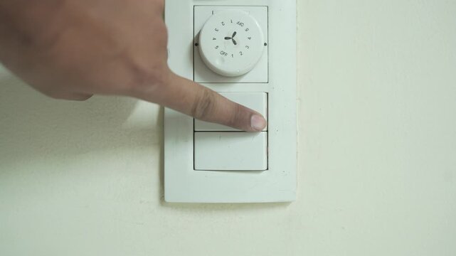 4K Vertical video showing a hand turning off an electrical switch, representing power control, energy saving, home safety, lighting shutdown, and daily household activity.