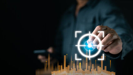 A person interacts with a glowing digital target interface above rising data bars, highlighting analytics precision and modern strategy in a dark tech focused setting boosting future tech growth.