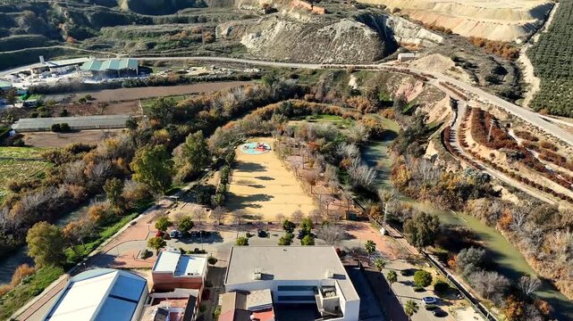 Genil River winding through Puente Genil Andalusia Spain with scenic valley cliffs park and olive groves under clear blue sky