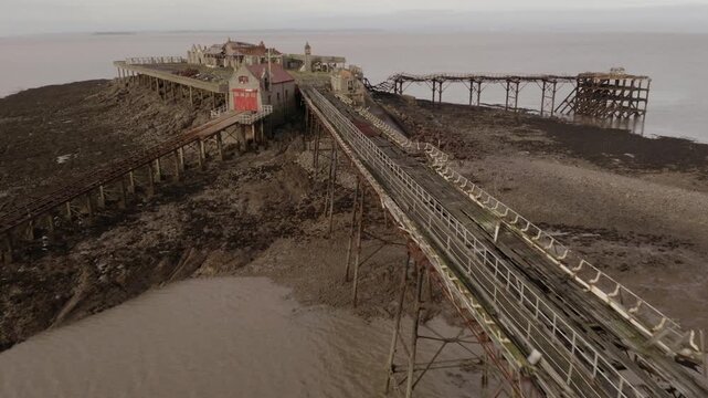 Aerial shot flying towards abandoned RNLI Lifeboat Station amongst Coastal Ruins of Birnbeck Pier in Weston-Super-Mare United Kingdom