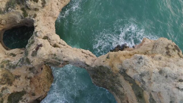 Aerial Top Down View of Coastal Cliff with Ocean Waves and Rock Formations