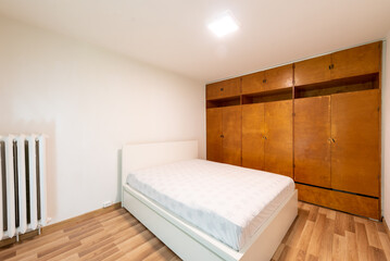 Minimalist Bedroom With Wooden Wardrobes and Modern White Bed