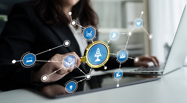 A businesswoman uses a magnifying glass over digital icons representing data and innovation, highlighting growth opportunities in a modern office setting. Crux - Powered by Adobe