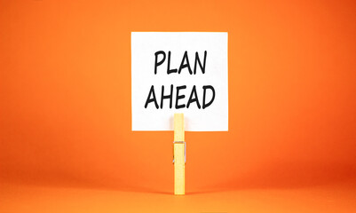 Plan ahead symbol. Concept word Plan ahead on beautiful white paper. Beautiful wooden clothespin. Beautiful orange background. Business plan ahead concept. Copy space.