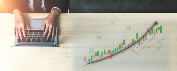 A business professional focuses on analyzing financial data on a laptop, featuring growth charts and statistical graphs in a modern office atmosphere. Impute