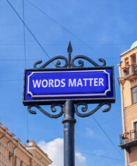 Fototapeta premium Words matter symbol. Concept word Words matter on beautiful blue road sign. Beautiful blue sky and buildings background. Business words matter concept. Copy space.