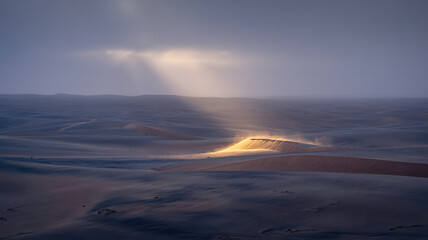 Sunbeams pierce through clouds over a vast ocean