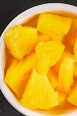 Pineapple canned chunks sweet fruit dessert tasty snack fresh delicious gourmet food background on the table rustic top view copy space keto and paleo diet vegetarian and vegan food