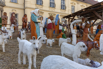 Traditional outdoor Nativity scene with large wooden figures. A close-up shot of an outdoor Christmas Nativity scene featuring life-sized or larger figures, clearly carved from wood