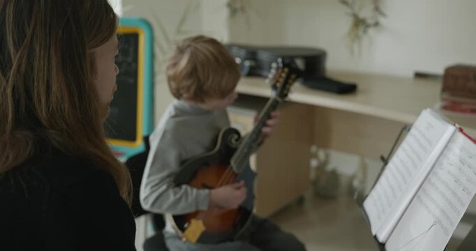 Male Teacher Gives Music Lesson for a Child. Man is Teaching Kid to Play Musical Instrument. 4K 10-bit