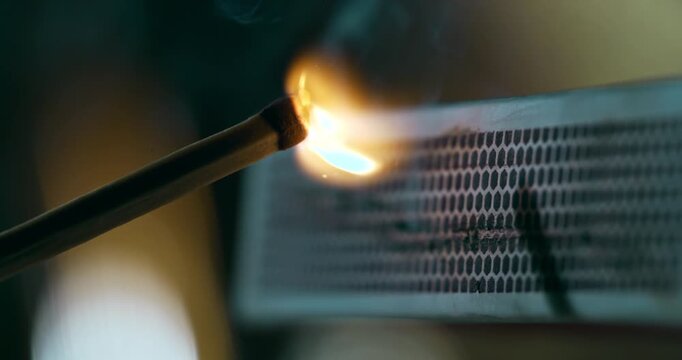 Slow motion close-up of a match being struck on a matchbox and bursting into flame at 1000 fps. Warm tones, detailed sparks, slow-motion ignition.