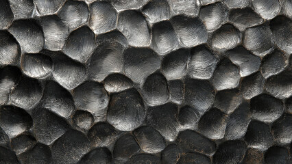 Dark metallic texture featuring organic, raised shapes with intricate, fingerprint-like ridges. A hammered metal surface with unique, rippled patterns.