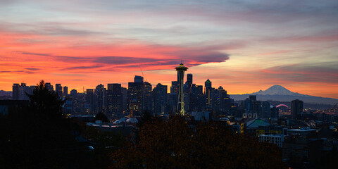 Pink clouds at dawn over Seattle cityscape with Mount Rainier on horizon