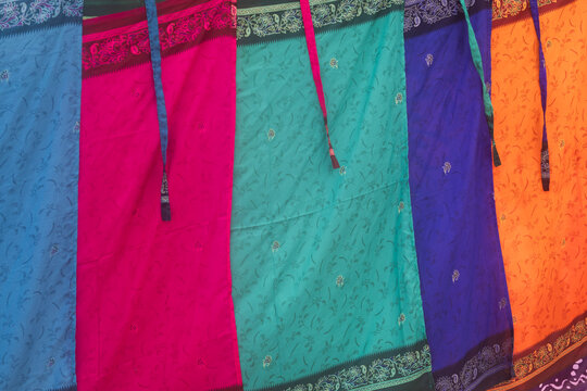 bright and colorful classic asian sarongs (traditional skirt or dress) background on washline