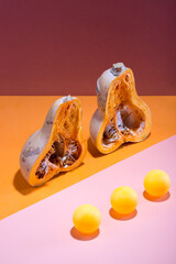 Abstract still life with a cut pumpkin and balls on a multi-colored background