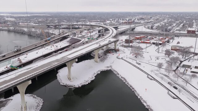 Interstate i70 and i71 highway system and roadway construction by car traffic on multi-lane roads near Columbus, Ohio during a snowy cold winter day from a drone shot and aerial view of cars and snow