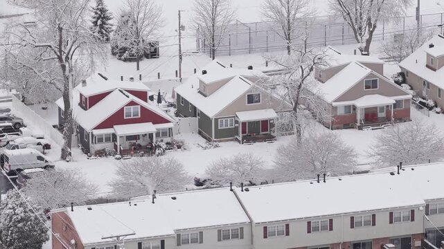 Upper class American suburban suburb near Columbus, Ohio in middle class neighborhood with homes, townhouses, houses, streets, and roads during a wintry and snowy winter storm with cold snow and ice
