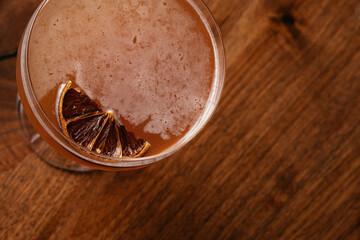 Close-up top view of a cocktail with dried orange slice and star anise garnish in a glass