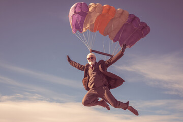 Elegant senior man jumping off a plane with a parachute 
