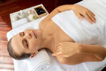 Caucasian woman customer enjoying relaxing anti-stress spa massage and pampering with beauty skin recreation leisure in day light ambient salon spa at luxury resort or hotel. Quiescent