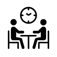 Two people sitting at a table with a clock on the wall representing a scheduled meeting time frame