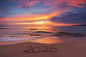 Selbstklebende Fototapeten Sportgeschäft Scenic sunrise over the sea horizon and beach text Happy New Year 2026 on the sand  © ValentinValkov