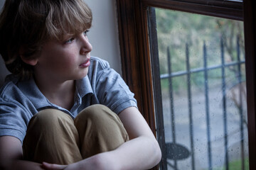 Sad Depressed Boy Young Male Child Looking Out of a Window