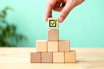 Hand placing checkmarked wooden cube symbolizing corporate compliance and goal achievement