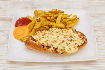 Sandwich gratin&eacute; au fromage servi avec des frites