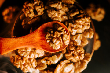 Peeled walnuts in a bowl with a wooden spoon ready for serving or cooking