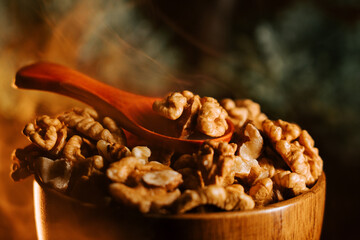 Peeled walnuts in a wooden bowl with a wooden spoon on a rustic background