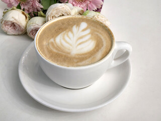 Cup of hot coffee with a bouquet of flowers. Coffee and flowers
