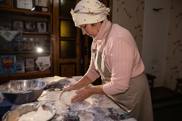 Grandma kneads dough for dumplings