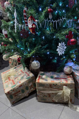 green christmas tree decorated with christmas decorations and gift boxes