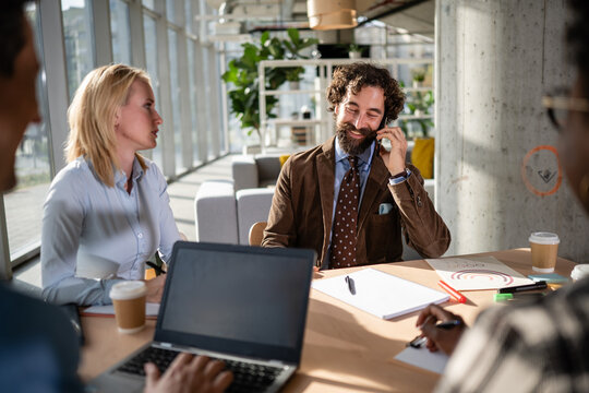 Business man talking on mobile phone during meeting