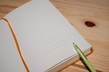 First page of an empty notebook with a green pen