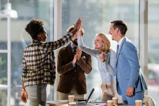 Diverse business team celebrating success with high five