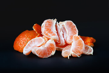 Peeled tangerine. Tangerine slices. Tangerine on a dark