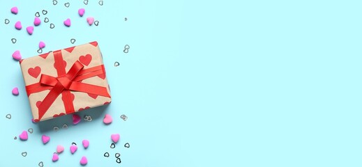 Gift box and hearts on light blue background with space for text. Valentine's Day celebration