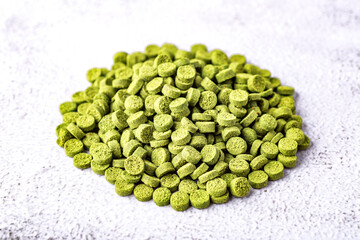 Aquarium fish fodder closeup.Pile of flakes and granules for feeding tropical aquarium fish,Side view.Dark Green round tablets of organic spirulina.Aquarium