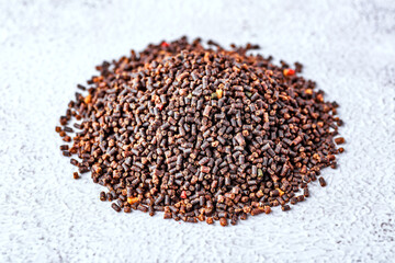 Aquarium fish fodder closeup.Pile of flakes and granules for feeding tropical aquarium fish,Side view.Aquarium