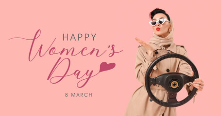 Young pin-up woman in sunglasses with steering wheel blowing kiss on pink background