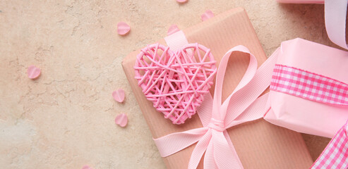Gift boxes with pink heart shaped decor on beige grunge background. Valentine's Day celebration