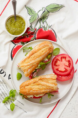 Baguette sandwich with pesto, prosciutto, tomato, burrata and arugula.selective focus